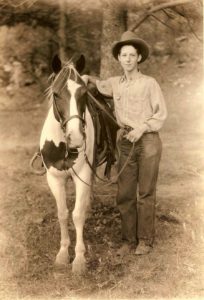 young man standing next to horse